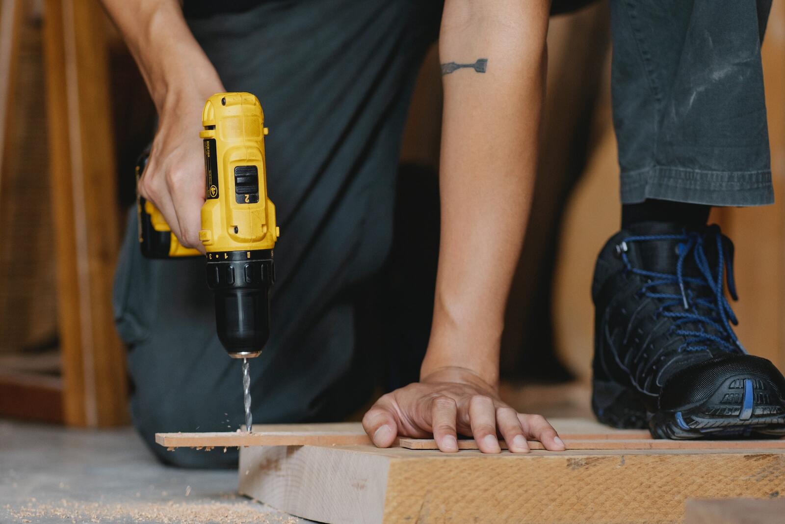 Hombre taladrando un tablón de madera